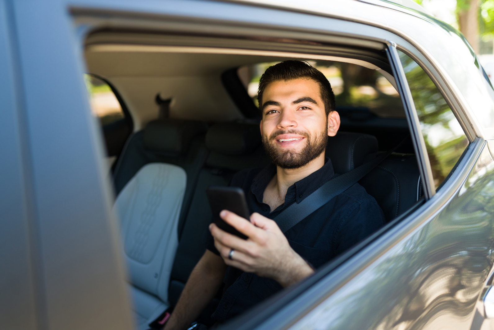 Cheerful passenger using a rideshare app